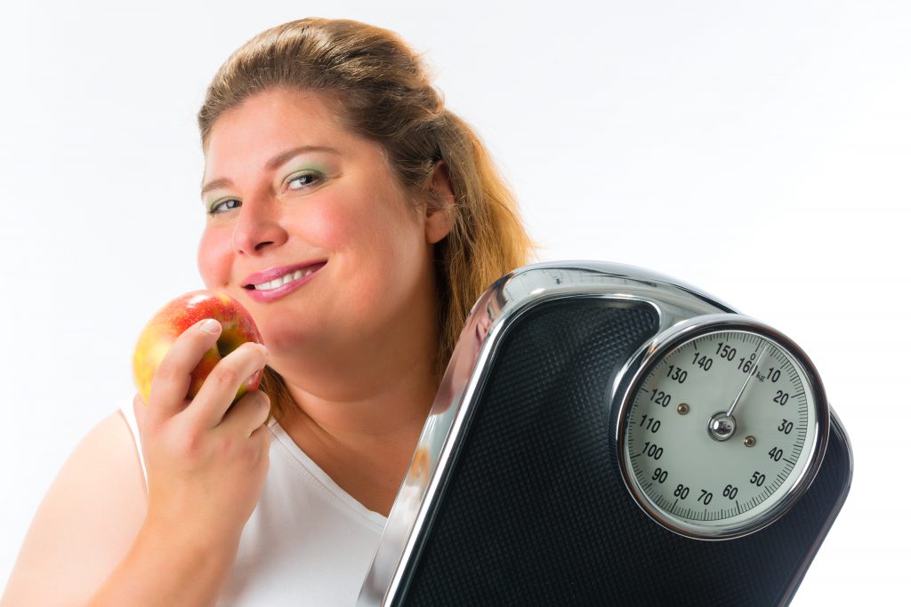 Obese woman with scale and apple